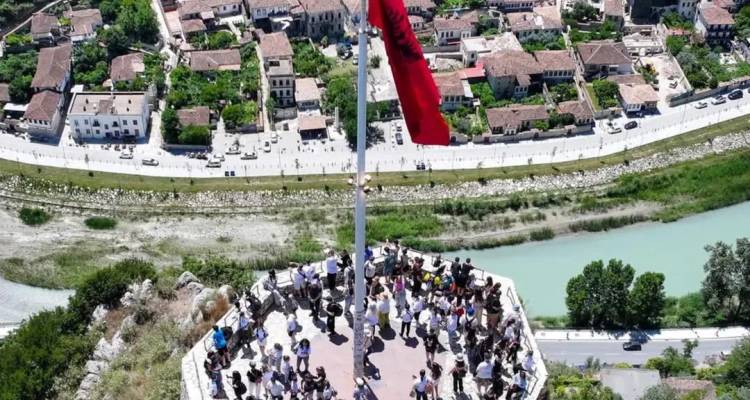 Vue depuis une colline avec un drapeau albanais et une ville en contrebas.