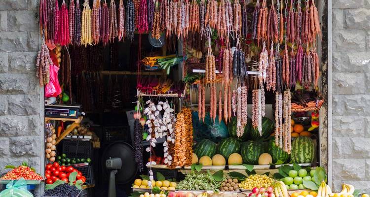Market stall with hanging dried goods and fruits.