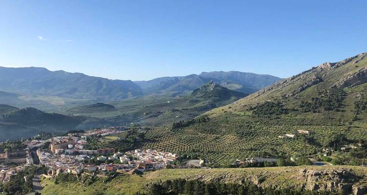 Amplio pueblo del valle andaluz rodeado de colinas verdes y olivares