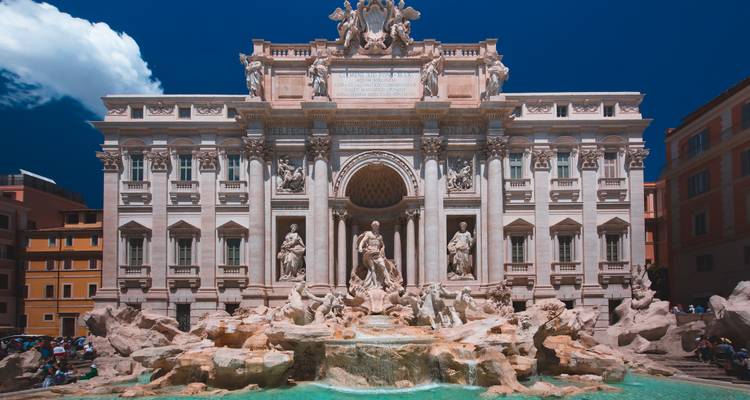 Fontaine célèbre avec des sculptures complexes sous un ciel bleu clair.
