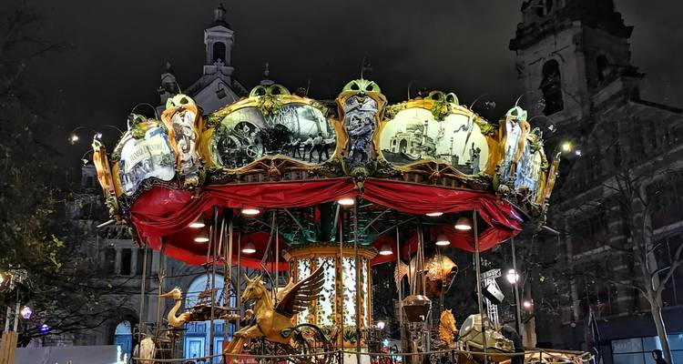Carrousel orné sur une place de ville au crépuscule.