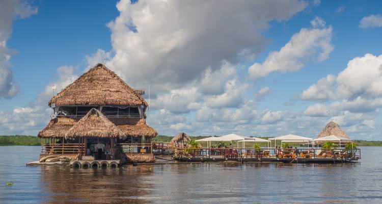 Restaurant au toit de chaume flottant sur une rivière