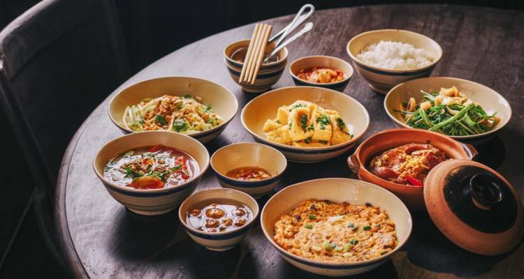 Vietnamese meal with multiple dishes on a dark wooden table.