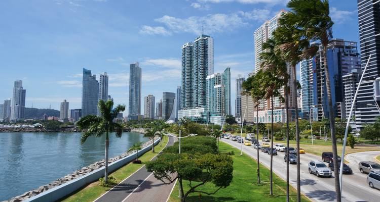Moderne Skyline von Panama City entlang der Küstenstraße mit Palmen und Verkehr