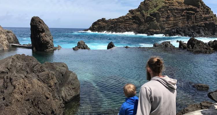 Person with a child looking at the ocean pools and rocky terrain.