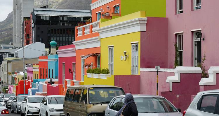 Kleurrijke stedelijke huizen met geparkeerde auto's langs de straat.
