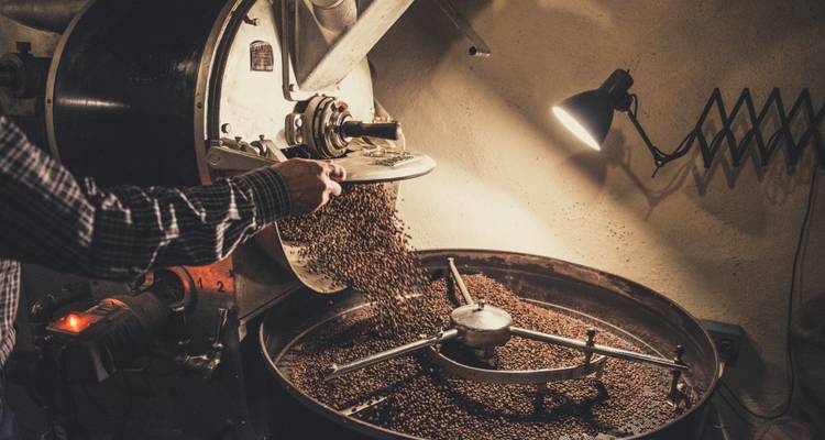 Koffiebonen roosteren in een mechanische rooster.