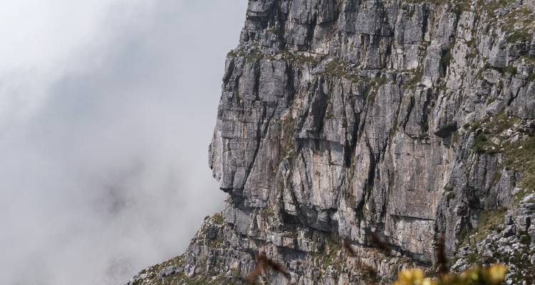 Rotswand met mist die van beneden oprijst.