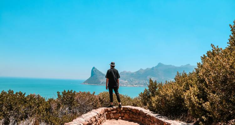 Persoon die geniet van een schilderachtig uitzicht op bergen en de oceaan.