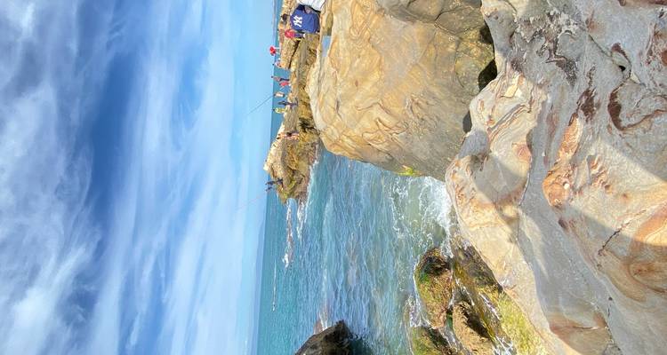 Rivage rocheux avec des pêcheurs qui lancent leurs lignes dans la mer.