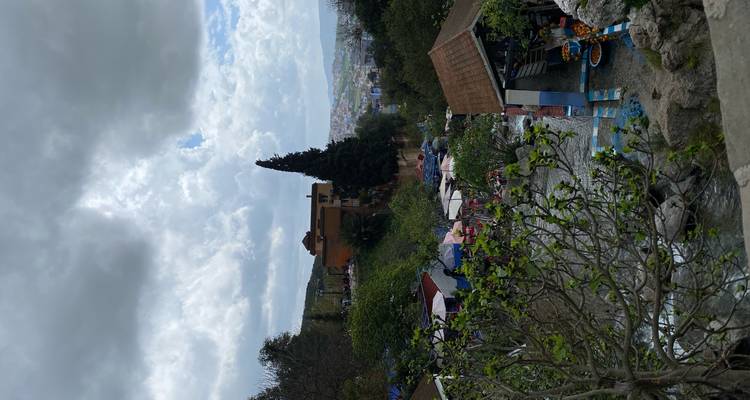 Scène de marché avec des étals et une vue sur des bâtiments urbains au loin.