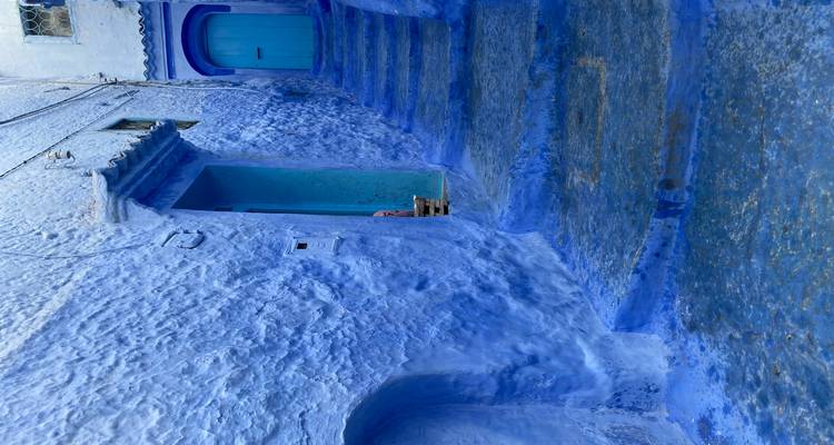 Escalier pavé peint en bleu dans une ruelle étroite.