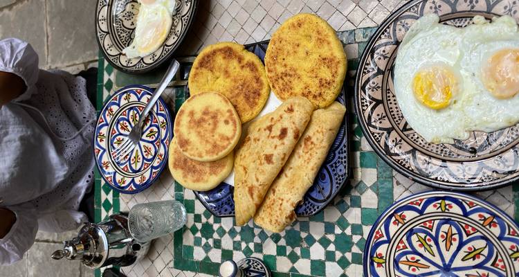 Petit-déjeuner marocain traditionnel avec du pain et du thé.