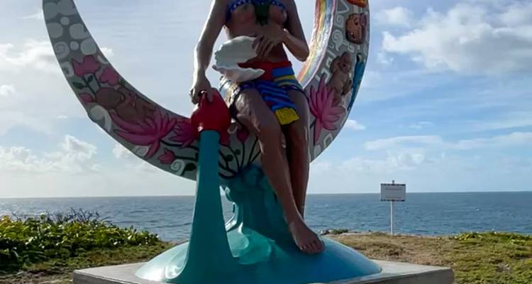 Sculpture sur un sentier côtier avec vue sur l'océan.