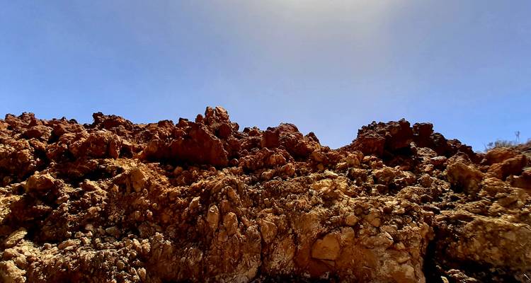 Surface rocheuse rouge sous un ciel dégagé.