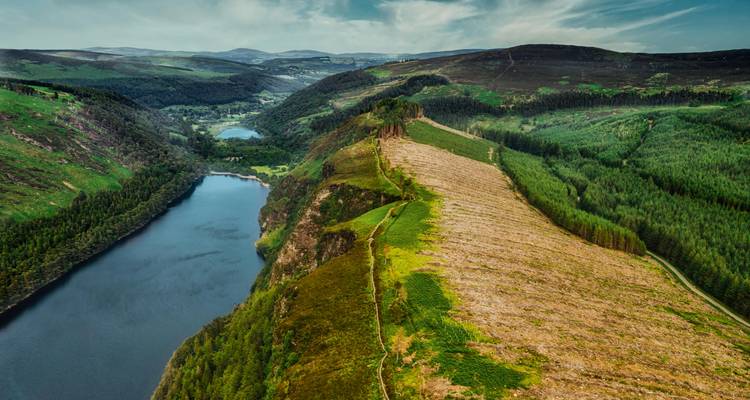 Vue aérienne d'une vallée et d'un lac dans un paysage montagneux.