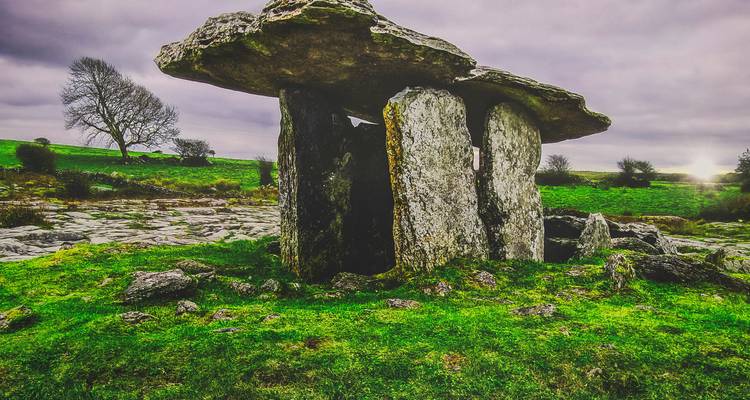 Un dolmen se dressant dans un champ vert éclatant.