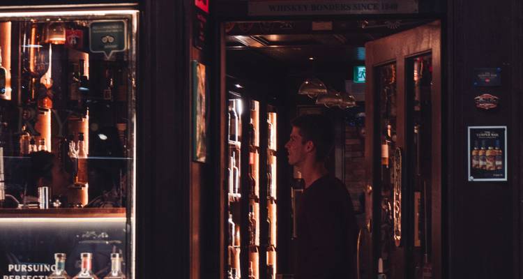Intérieur d'un bar à whisky avec une personne qui parcourt.