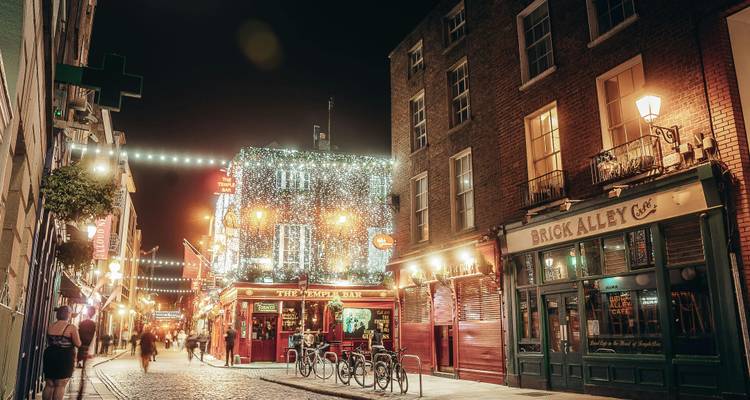 Zone de Temple Bar illuminée la nuit avec des lumières colorées.