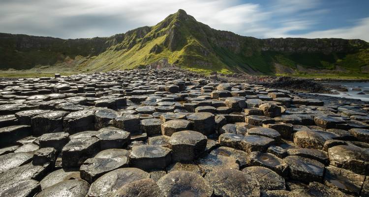 Chaussée des Géants avec colonnes de basalte et collines lointaines.