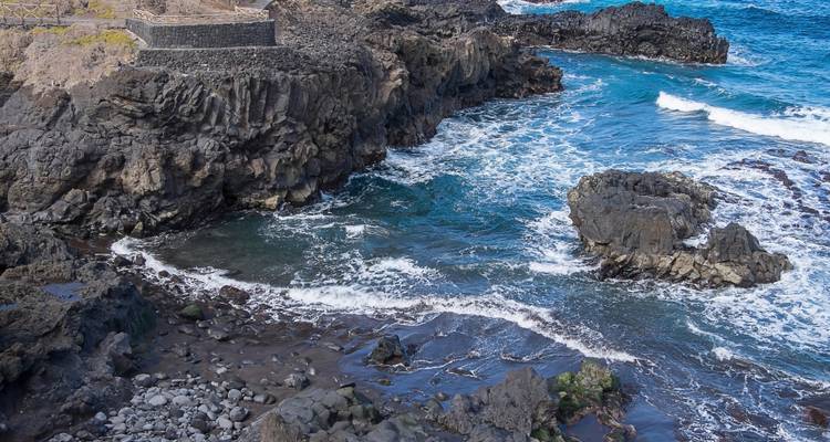 A rocky coastline with waves crashing against the shore.