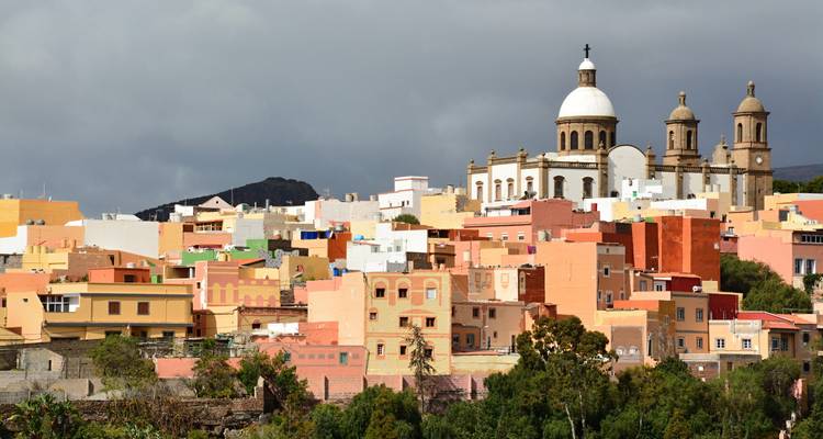 A vibrant cityscape with colorful buildings and a church dome.