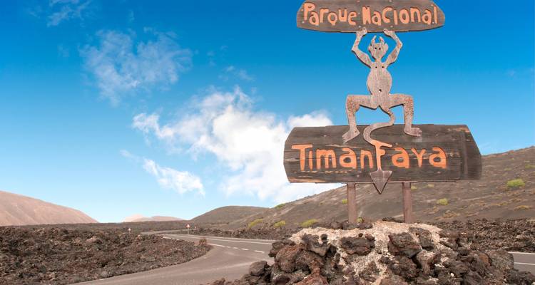 Panneau du parc national de Timanfaya sur un paysage volcanique.