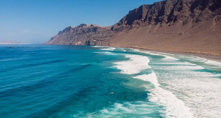 Belle plage avec des eaux turquoise et des falaises.