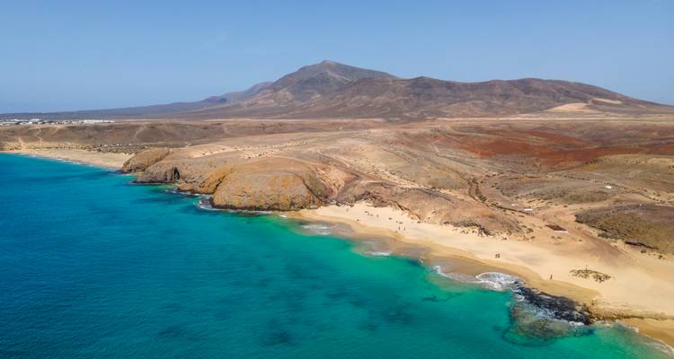 Vue aérienne du littoral avec une eau bleue claire.