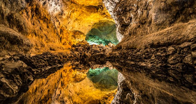 Vue intérieure d'une grotte avec un bassin réfléchissant.