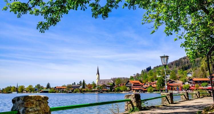 Vista panorámica de un lago con un pueblo y una iglesia en su orilla.