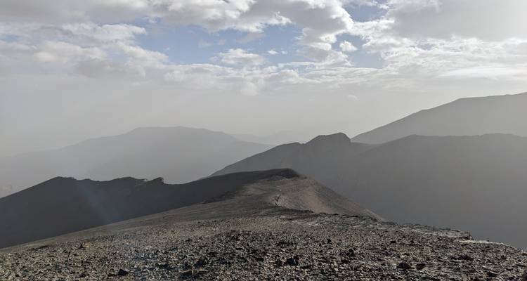 Bergige Landschaft mit bedecktem Himmel, der Schatten wirft.