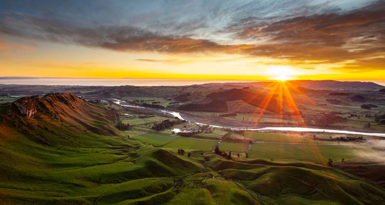 Un magnifique lever de soleil sur les collines verdoyantes ondulantes et les plaines fluviales de la baie de Hawke vus depuis le pic Te Mata