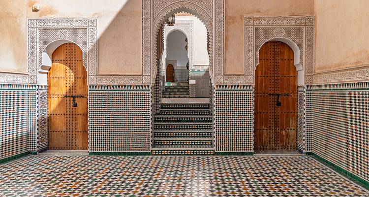 Intricately tiled courtyard with arched doorways.