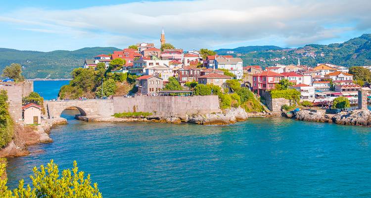Vue panoramique d'une ville côtière historique avec des fortifications.