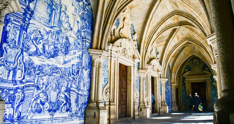 Intricate blue tile murals on a historic building's arched walkway.