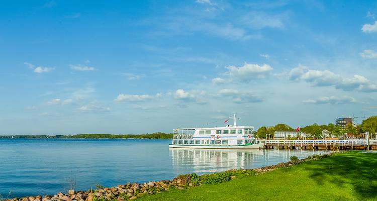 Vue sur la rivière avec un bateau d'excursion amarré à un quai par une journée ensoleillée