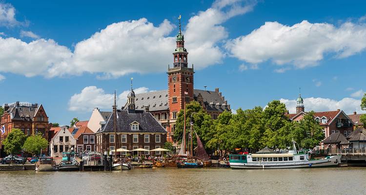 Vue historique de la ville avec une tour d'horloge proéminente et un cours d'eau