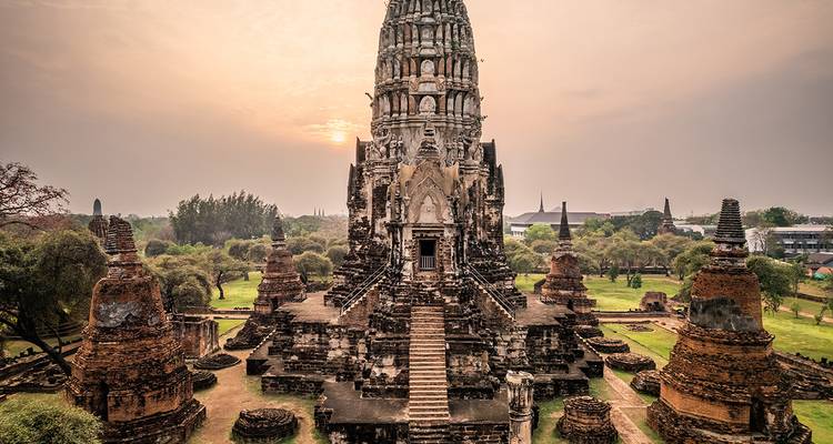 An ancient temple complex at sunset with historic architecture and ruins.