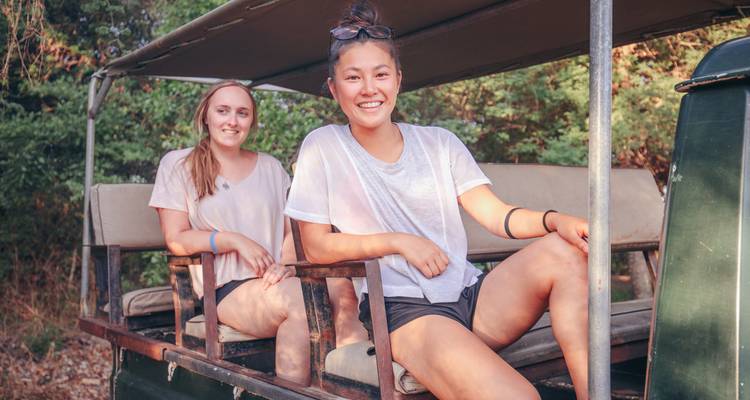 Two people sitting in an open safari vehicle