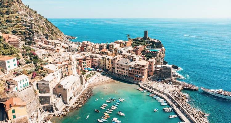 Coastal village with colorful buildings on a cliff facing the ocean.