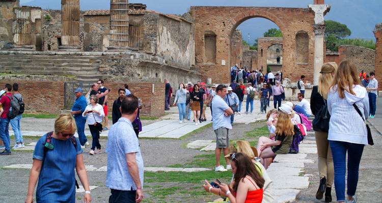 Tourists exploring ancient ruins with arches.