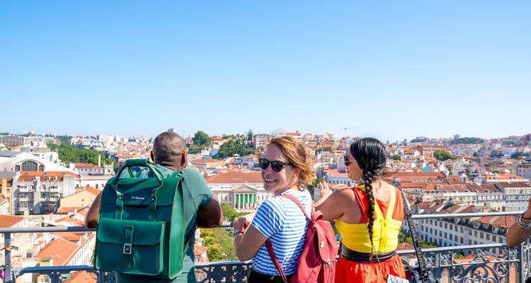 Group of people enjoying a rooftop view of a city below.