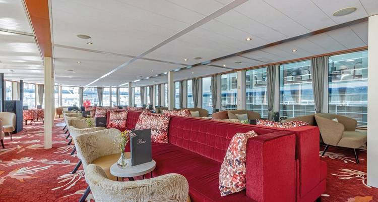 Interior of a boat lounge with red and beige seating.