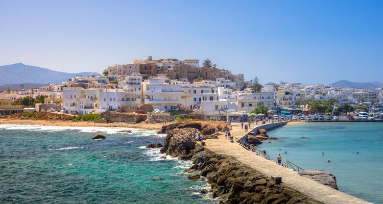 Coastal town with white buildings and a stone walkway.