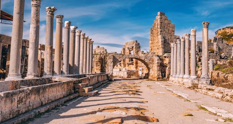 Ancient ruins with stone columns lining a pathway.