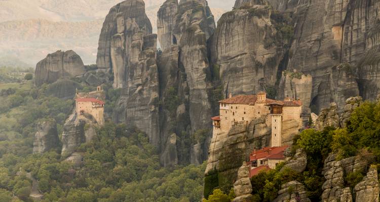 Monasteries on the cliffs in a misty valley.