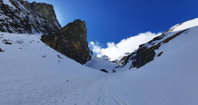 Two hikers in a snowy mountain pass