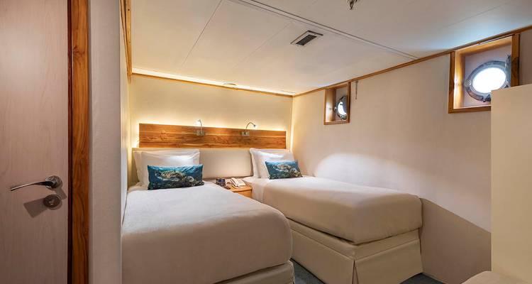 Una cabaña con dos camas individuales y decoración náutica.