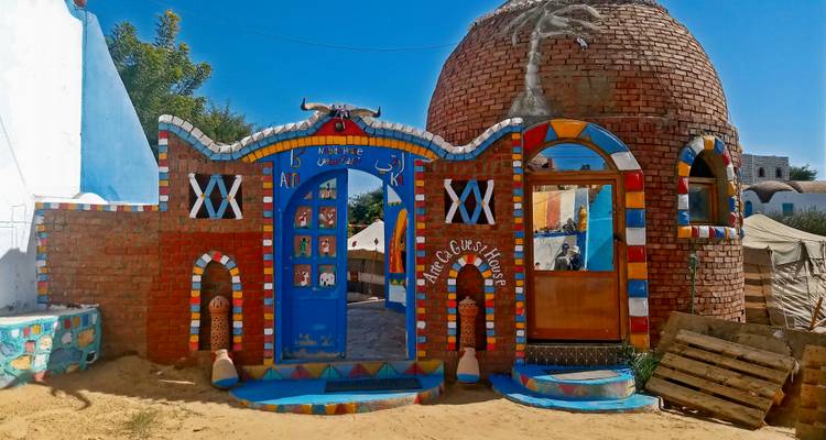 Maison nubienne traditionnelle aux couleurs vives avec des œuvres d'art.